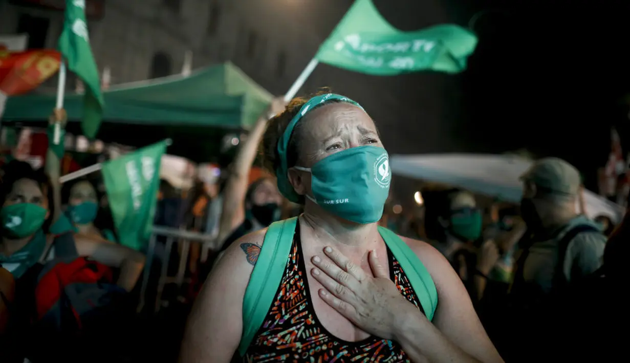 Aktivis hak-hak aborsi menangis setelah anggota parlemen menyetujui undang-undang yang melegalkan aborsi di luar Kongres, Buenos Aires, Argentina, Rabu (30/12/2020). Argentina memastikan sebagai negara Amerika Latin pertama yang melegalkan aborsi. (AP Photo/Natacha Pisarenko)