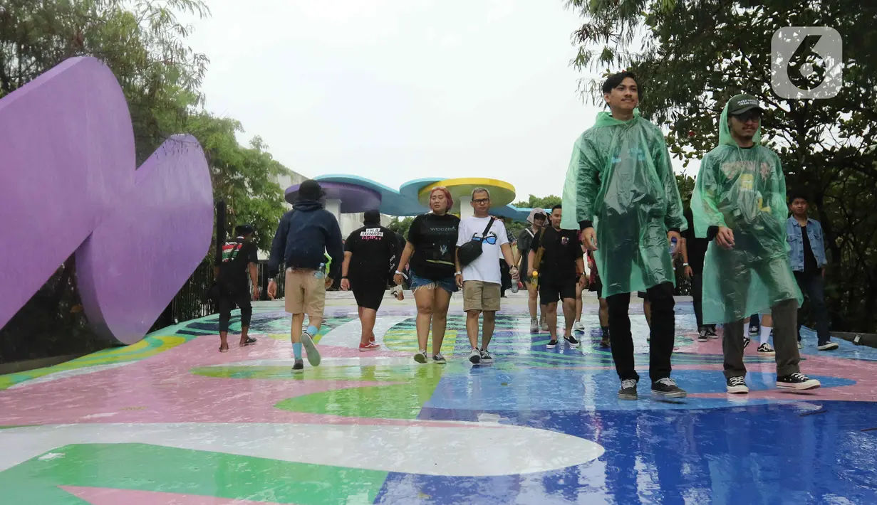 Sejumlah pengunjung mengenakan jas hujan saat memasuki area festival musik Soundrenaline 2022 di Allianz Ecopark, Ancol, Jakarta Utara, Sabtu (26/11/2022). Festival musik Soundrenaline 2022 menampilkan musisi seperti Hollow Coves, Weezer, Neck Deep, Clean Bandit, Isyana Sarasvati, Pure Saturday yang berlangsung pada 26 dan 27 September 2022. (Liputan6.com/Herman Zakharia)
