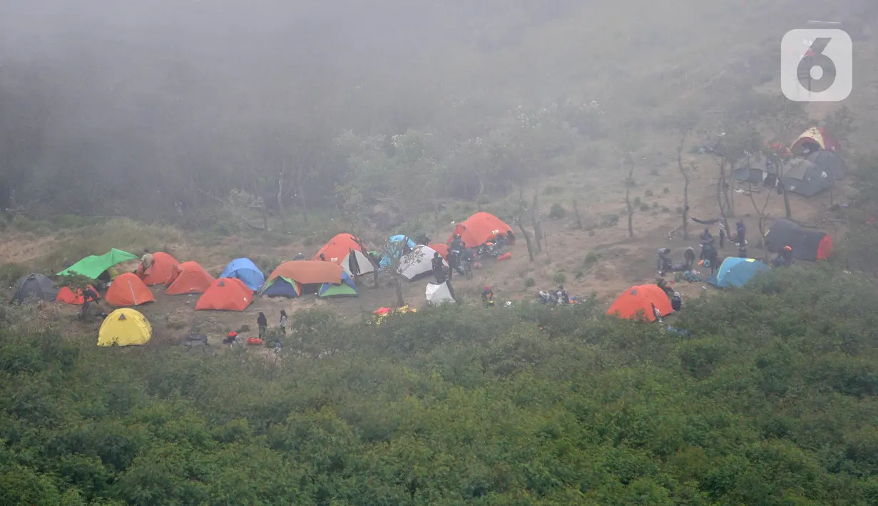 Aktivitas pendaki saat mendirikan tenda di salah satu pos pendakian Gunung Sindoro via Jalur Alang-Alang Sewu, Wonosobo, Jawa Tengah, Sabtu (11/9/2021). Wisata pendakian Gunung Sindoro kembali dibuka pasca meredanya kasus Covid-19 di Jawa-Bali yang memasuki PPKM Level 3. (merdeka.com/Iqbal Nugroho)
