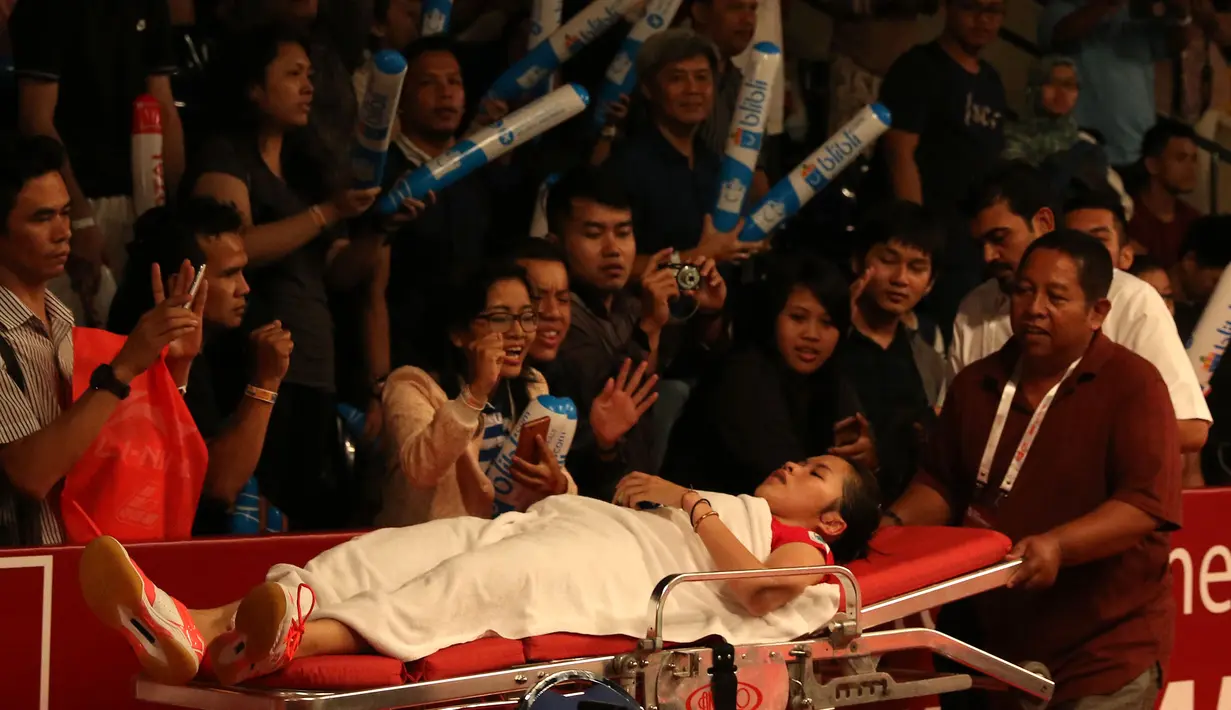 Pemoonton memberi semangat kepada Ratchanok Intanon saat dibawa keluar lapangan setelah mengalami cedera kaki kanan . Kamis (13/8/2015). (Bola.com/Arief Bagus)