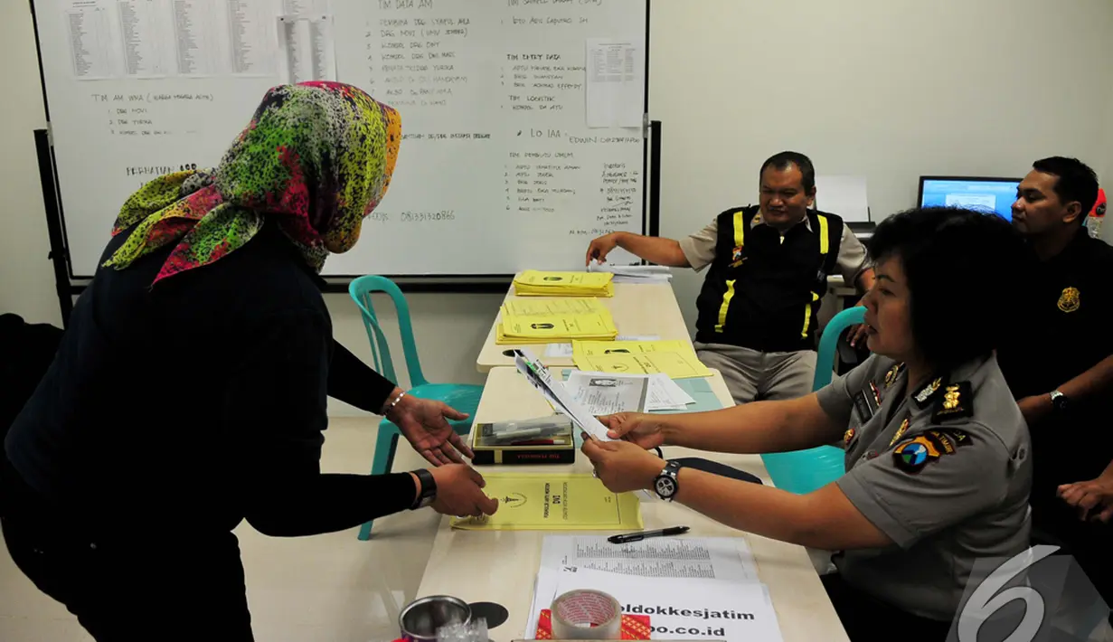 Sejumlah petugas terlihat sibuk mengumpulkan data antemortem penumpang AirAsia QZ8501 di Posko DVI, Bandara Juanda, Surabaya, Rabu (31/12/2014). (Liputan6.com/Johan Tallo)