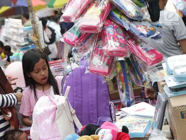 Seorang ibu bersama anaknya memilih keperluan sekolah di Pasar Asemka, Jakarta, Selasa (7/9/2019). Jelang dimulainya tahun ajaran baru, Pasar Asemka ramai dikunjungi warga untuk berbelanja keperluan sekolah. (Liputan6.com/Helmi Fithriansyah)