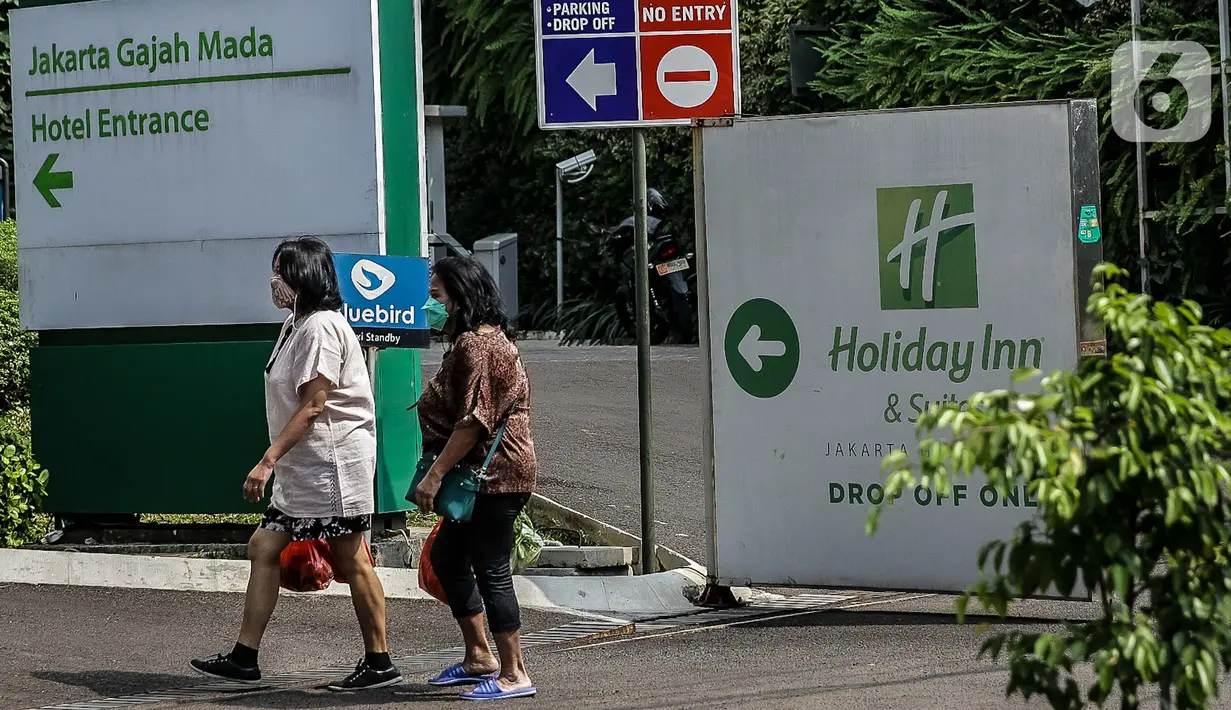 Dua wanita berjalan di sekitar Hotel Holiday Inn, Gajah Mada, Jakarta, Minggu (25/4/2021). Satgas Penanganan COVID-19 menyiapkan Hotel Holiday Inn sebagai tempat karantina bagi 141 WNA khususnya asal India yang negatif COVID-19 untuk dipantau 14 hari ke depan. (Liputan6.com/Faizal Fanani)