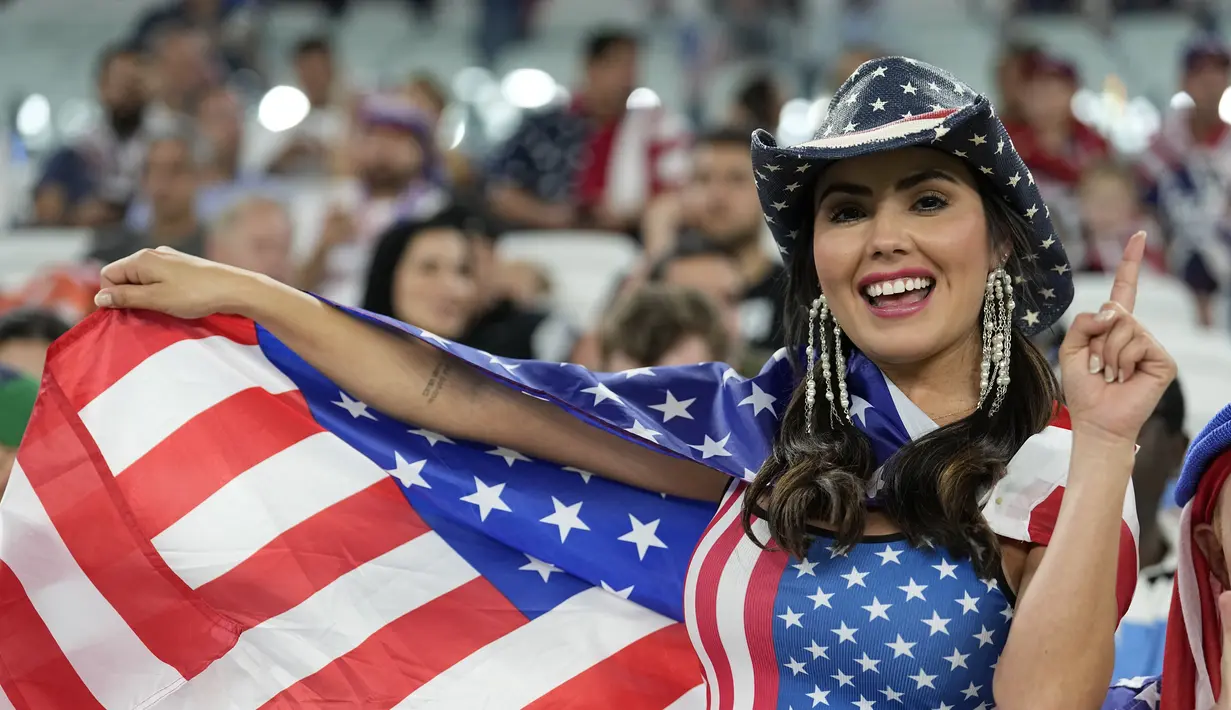 Seorang fans wanita Amerika Serikat bersorak menjelang pertandingan  grup B Piala Dunia antara Iran melawan Amerika Serikat di Stadion Al Thumama di Doha, Qatar, Selasa, 29 November 2022. (AP Photo/Ebrahim Noroozi)