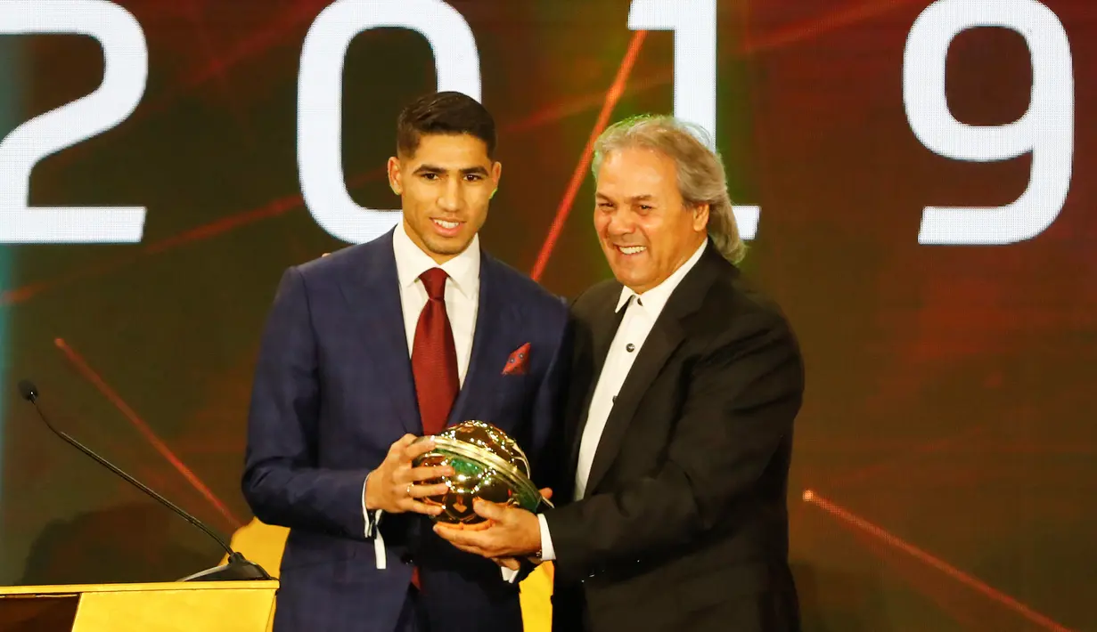 Bek berdarah Maroko, Achraf Hakimi menerima penghargaan Pemain Muda Terbaik Afrika 2019 pada acara CAF Awards di kota wisata Mesir, Hurghada, Selasa (7/1/2020). Selain Pemain Muda Terbaik Afrika 2019, acara itu juga mengumumkan beberapa penghargaan bergengsi lainnya.  (Khaled DESOUKI/AFP)