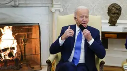 Presiden AS Joe Biden melepas masker saat berbicara pada pertemuan dengan Kanselir Jerman Olaf Scholz di Kantor Oval Gedung Putih, Washington, AS, 7 Februari 2022. AS dan Jerman menjalin kerja sama untuk mencegah agresi Rusia di Eropa serta tantangan yang ditimbulkan China. (AP Photo/Alex Brandon)