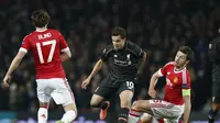 Gelandang Liverpool, Philippe Coutinho (tengah) beraksi di tengah kawalan dua pemain Manchester United, Michael Carrick (kanan) dan Daley Blind, Jumat (18/3/2016) dini hari WIB.(Reuters/Andrew Yates)