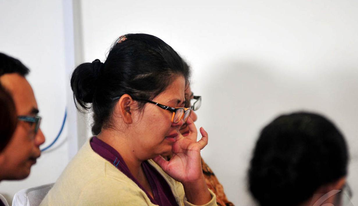 Seorang keluarga penumpang AirAsia QZ8501 memejamkan mata saat berdoa bersama di Crisis Center AirAsia di Terminal II Bandara Juanda, Surabaya, Selasa (30/12/2014). (Liputan6.com/Johan Tallo)