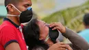 Seorang wanita menangis saat upacara pemakaman korban banjir dan tanah longsor di Mocoa, Kolombia, (3/4). Bencana tanah longsor tersebut disebabkan hujan deras yang terus mengguyur sejumlah kawasan di Kolombia. (AP Photo / Fernando Vergara)