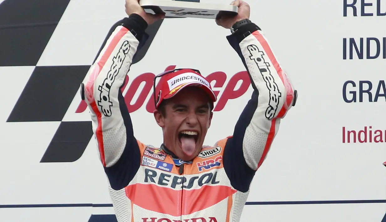 Pembalap Repsol Honda, Marc Marquez (tengah) mengangkat pialanya usai memenangkan balapan di sirkuit Indianapolis, (9/8/2015). Marc Marquez dinobatkan sebagai juara setelah Finish pertama pada seri kali ini. (REUTERS/Brent Smith)