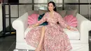 Satu lagi dress yang membuat Bunga Zainal tampil bak princess. Dengan long dress lengan panjang berwarna merah muda bermotif floral, yang memiliki high slit, Bunga Zainal berpose cantik sambil duduk, sudah seperti putri raja, bukan? Foto: Instagram.