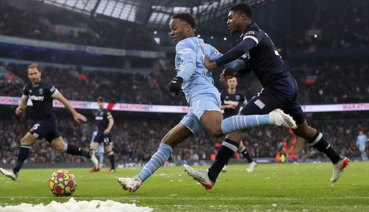Penyerang Manchester City, Raheem Sterling membawa bola dari kawalan pemain West Ham United, Ben Johnson pada pertandingan Liga Inggris di stadion Etihad, Inggris, Minggu (28/11/2021). Hasil Ini membawa Manchester City salip Liverpool di posisi dua klasemen Liga Inggris. (AP Photo/Scott Heppell)