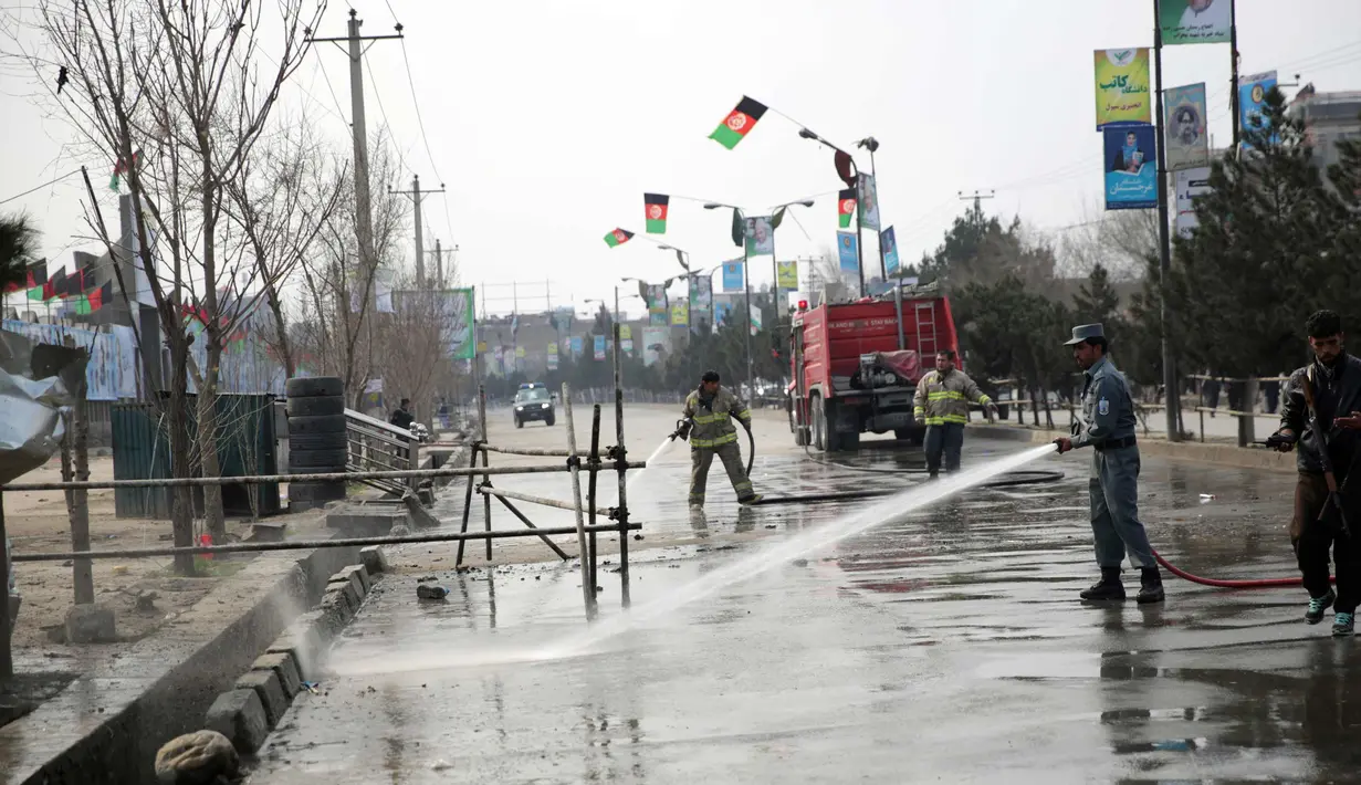 Polisi dan pemadam kebakaran membersihkan lokasi serangan bom bunuh diri di Kabul (9/3). Seorang pembom bunuh diri yang menargetkan kelompok minoritas Afghanistan, Hazaras, meledakkan dirinya di sebuah pos pemeriksaan polisi. (AP Photo / Massoud Hossaini)