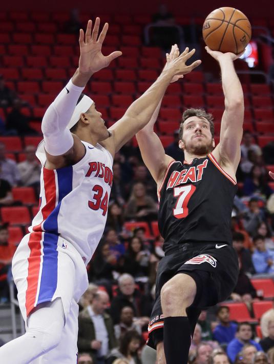 Pemain Miami Heat, Goran Dragic (7) melakukan tembakan melewati adangan pemain Detroit Pistons, Tobias Harris (34) pada laga NBA basketball game di Little Caesars Arena, Detroit, (12/11/2017). Detroit Pistons menang 112-103. (AP/Duane Burleson)