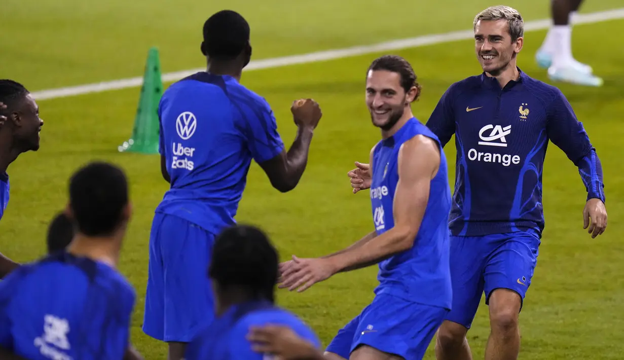Gelandang Prancis, Antoine Griezmann dan Adrien Rabiot tertawa saat melakukan pemanasan bersama rekan satu timnya selama sesi latihan di stadion Jassim Bin Hamad di Doha, Qatar, Jumat (16/12/2022). Prancis akan melawan Argentina pada pertandingan final Piala Dunia 2022 di Lusail Iconic Stadium, Minggu (18/12/2022). (AP Photo/Petr David Josek)
