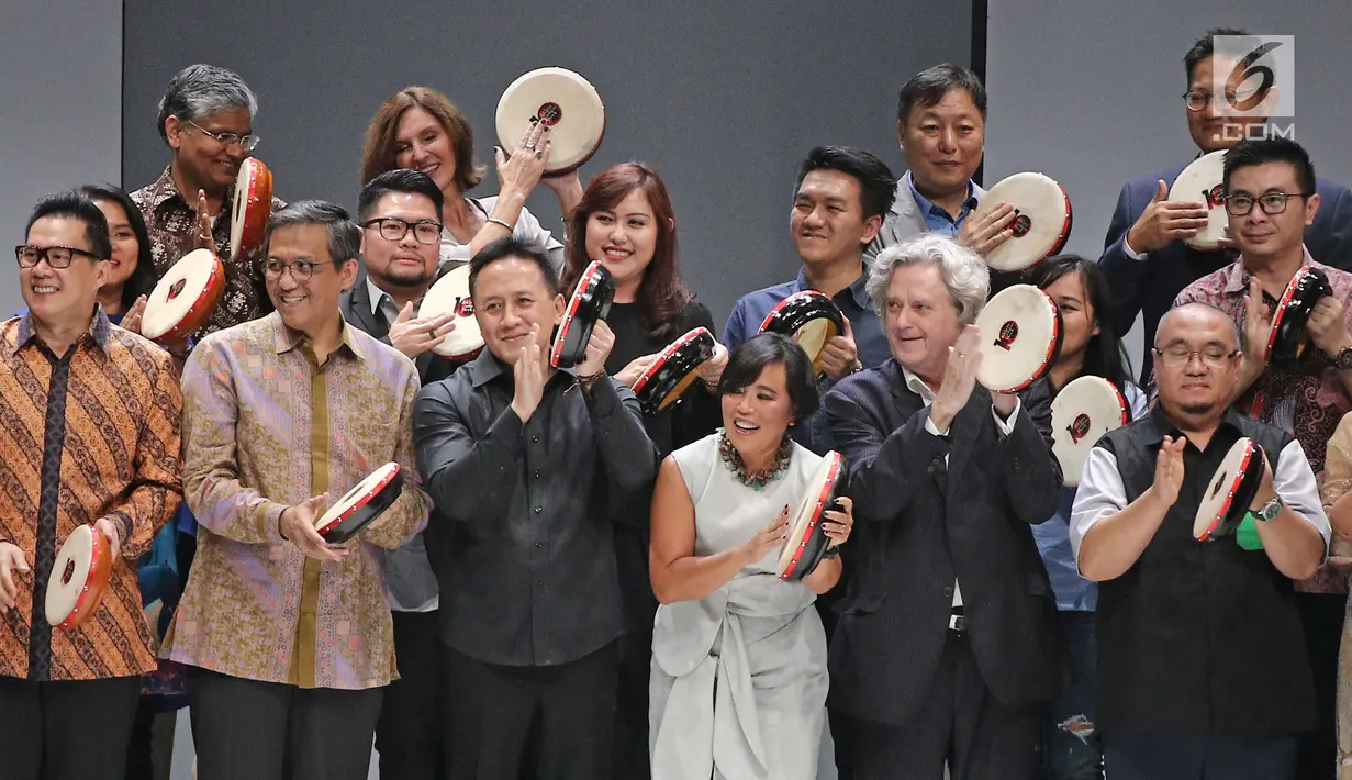 Kepala Badan Ekonomi Kreatif Triawan Munaf (ketiga kiri), dan Ketua JFW Svida Alisjahbana (ketiga kanan) memukul rebana pada pembukaan Jakarta Fashion Week 2018 di Senayan City, Jakarta, Sabtu (21/10). (Liputan6.com/Herman Zakharia)