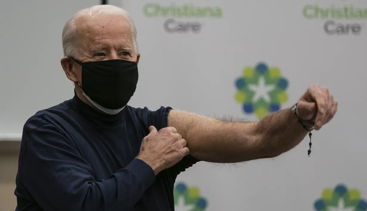 Presiden terpilih AS Joe Biden mengulurkan tangannya setelah menerima vaksin virus corona Pfizer-BioNTech di Rumah Sakit Christiana di Newark, Delaware, Senin (21/12/2020). Istrinya, Jill Biden, menerima rangkaian vaksin pertamanya pada hari sebelumnya. (Alex Edelman / AFP)