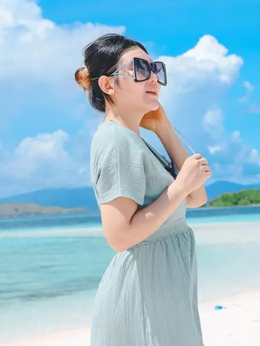Outfit Via Vallen selama liburan ini terlihat stylish. Berjalan menyusuri pantai, pelantun lagu Meraih Bintang ini tampak anggun dengan dress berwarna biru. Mengenakan kacamata dengan frame kotak, membuatnya tampak makin menawan.(Liputan6.com/IG/@viavallen)