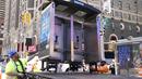 Para pekerja memindahkan bilik telepon umum terakhir NYC di dekat Seventh Avenue dan 50th Street di Midtown Manhattan, New York City, pada 23 Mei 2022. Bilik telepon itu adalah salah satu peninggalan terakhir dari lebih dari 8.000 telepon umum di seluruh kota yang telah disingkirkan satu per satu selama beberapa tahun terakhir. (TIMOTHY A. CLARY / AFP)