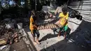 Anak-anak membawa bejana tanah liat di salah satu bengkel tembikar tertua di Beit Lahia, Jalur Gaza, 15 Agustus 2022. (AP Photo/Hatem Moussa)