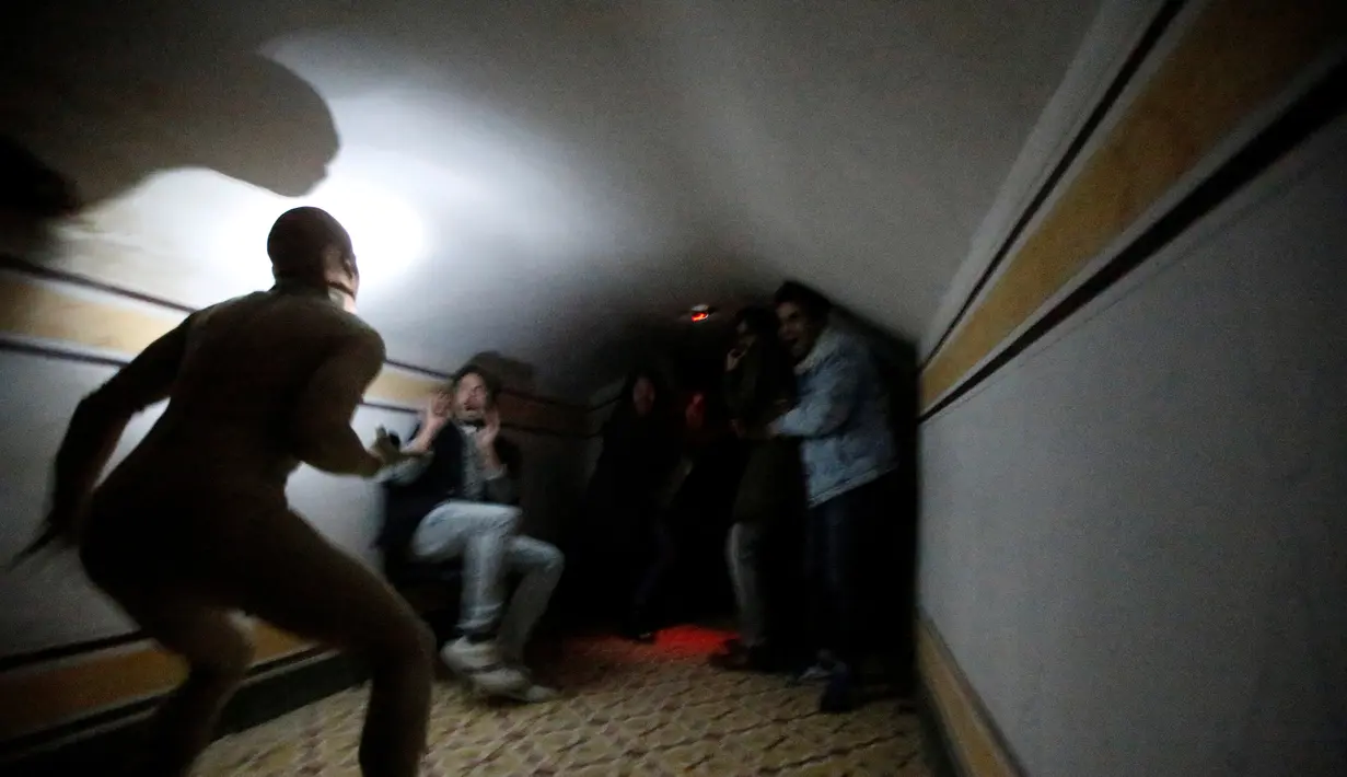 Ekspresi ketakutan pengunjung saat menemui hantu di Quinta Nova da Assuncao, Belas, Portugal (13/5). Rumah hantu ini berisi 25 kamar dipenuhi penampakan bayangan dan suara dari pintu yang menutup secara acak. (REUTERS/Rafael Marchante)
