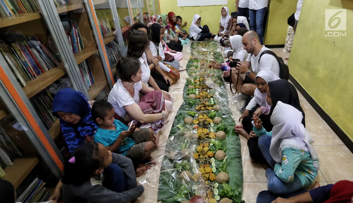 Sejumlah anak yatim, kaum dhuafa bersama lima WNA menikmati makanan nasi liwet sambil lesehan di Rumah Amalia, Ciledug, Kota Tangerang, Sabtu (3/3). Lima WNA itu tergabung dalam komunitas couchsurfing Indonesia. (Liputan6.com/Fery Pradolo)