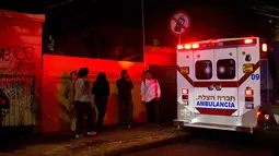 Warga setempat berdiri diseberang garasi parkir bawah tanah yang runtuh di sebuah kompleks di Mexico City (10/4). (AP Photo/Rebecca Blackwell)