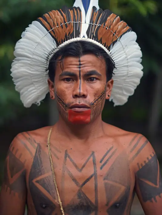 Seorang pria dari suku Fulni-o berpose untuk difoto di Rio de Janeiro, Brasil (14/4). Brasil merayakan Indian Day yang digelar setiap tanggal 19 April untuk menghormati masyarakat adat dan budaya setempat.  (AFP/Carl De Souza)