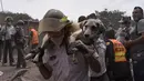 Seorang petugas menggendong anjing yang berhasil diselamatkan dari letusan gunung Feugo di desa San Miguel Los Lotes, Guatemala (5/6). Dua hari setelah letusan tim penyelamat mencari dan mengevakuasi korban letusan gunung Fuego. (AFP/Johan Ordonez)
