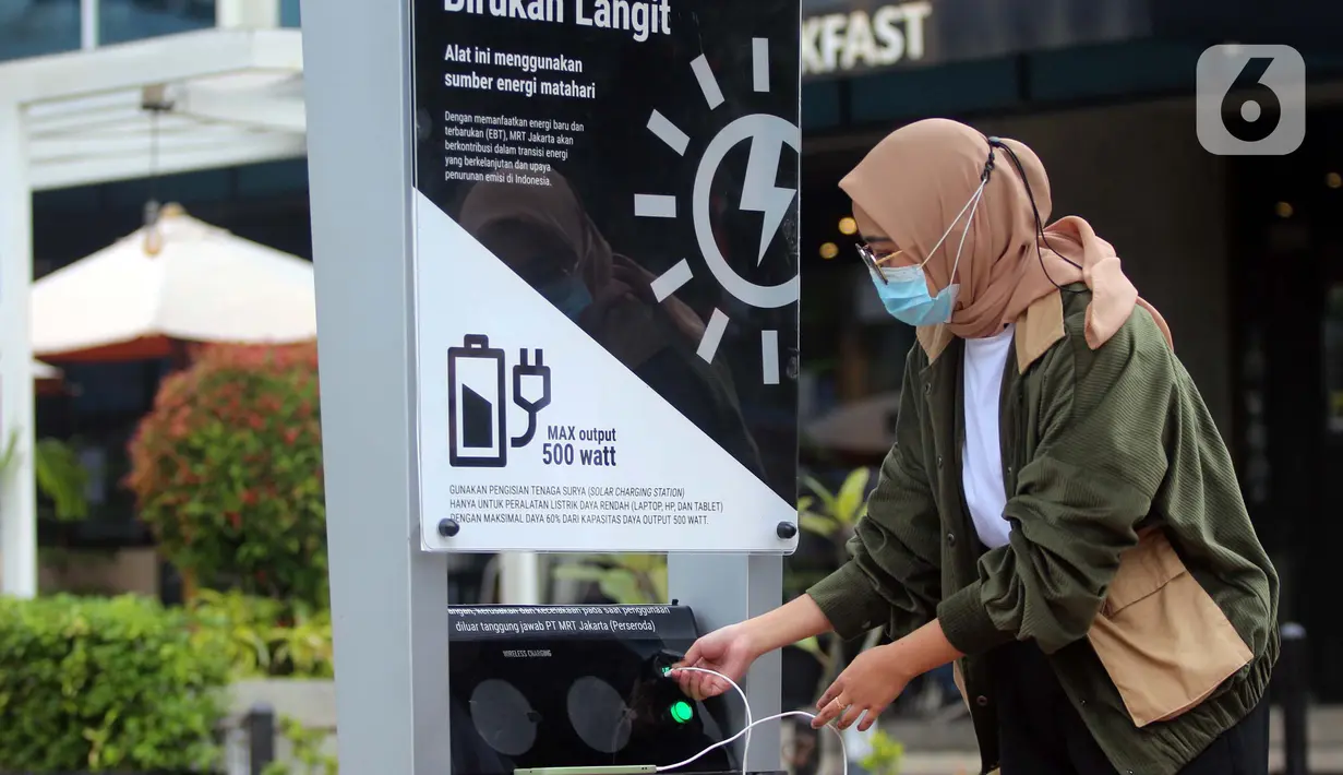 Seorang perempuan mengisi ulang daya ponsel pada stasiun Pengisian Listrik Bertenaga Surya atau Solar Charging Station di kawasan Transit Oriented Development (TOD) I Dukuh Atas, Jakarta, Rabu (10/11/2022). Fitur unit pengisi daya ini terdiri dari solar panel berkapasitas 100 Wp, dua fitur wireless charging 15 watt, dua USB charging DC 5V, dua socket AC 220V, dan rak sepeda. (Liputan6.com/Johan Tallo)