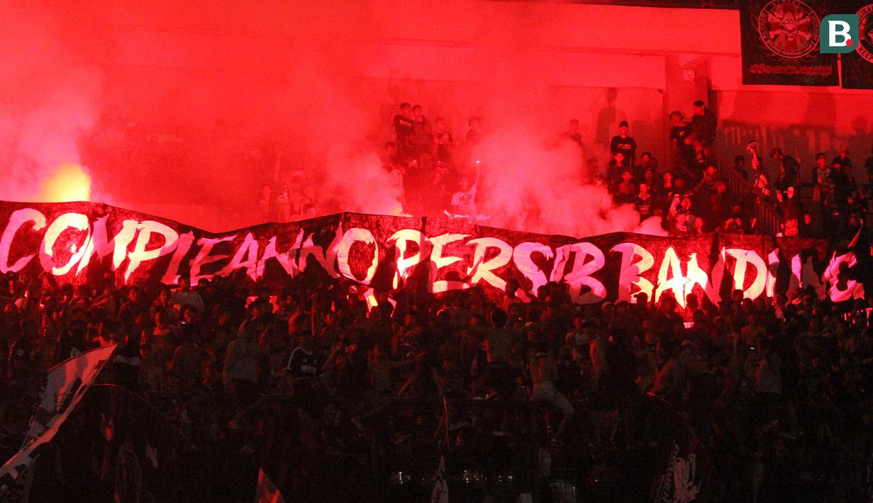 Bobotoh Persib menyalakan flare usai laga melawan Arema FC pada laga persahabatan di Stadion GBLA, Bandung, Minggu (18/3/2018). Persib menang 2-1 atas Arema FC. (Bola.com/Asprilla Dwi Adha)