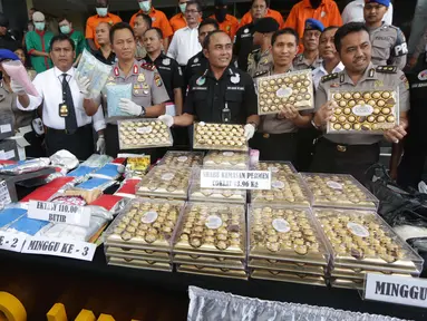 Petugas Dit Narkoba Polda Metro Jaya merilis hasil Operasi Bersinar Jaya 2016 di Jakarta, Rabu (13/4).  Selain menyita sejumlah barang bukti, petugas juga mengamankan sembilan tersangka, empat diantaranya merupakan WNA. (Liputan6.com/Gempur M Surya)