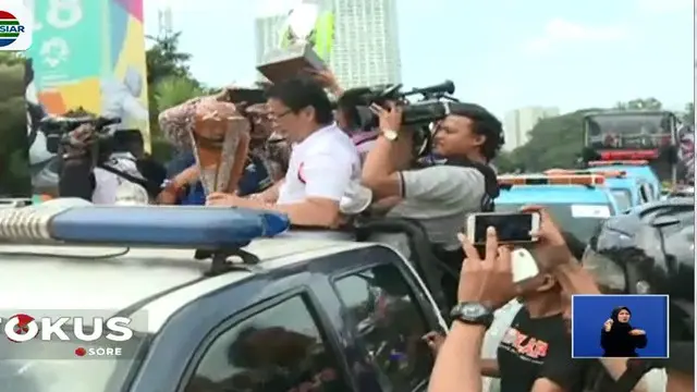 Konvoi kendaraan bergerak dari Gelora Bung Karno melalui Jalan Jenderal Sudirman menuju gedung Balai Kota.