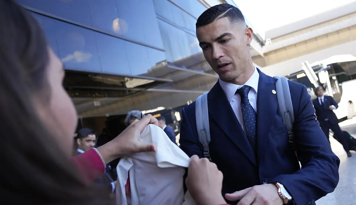 Namun ketika Cristiano Ronaldo turun dari bis dan akan masuk kedalam airport, ia sempat meladeni seorang wanita. (AP Photo/Armando Franca)