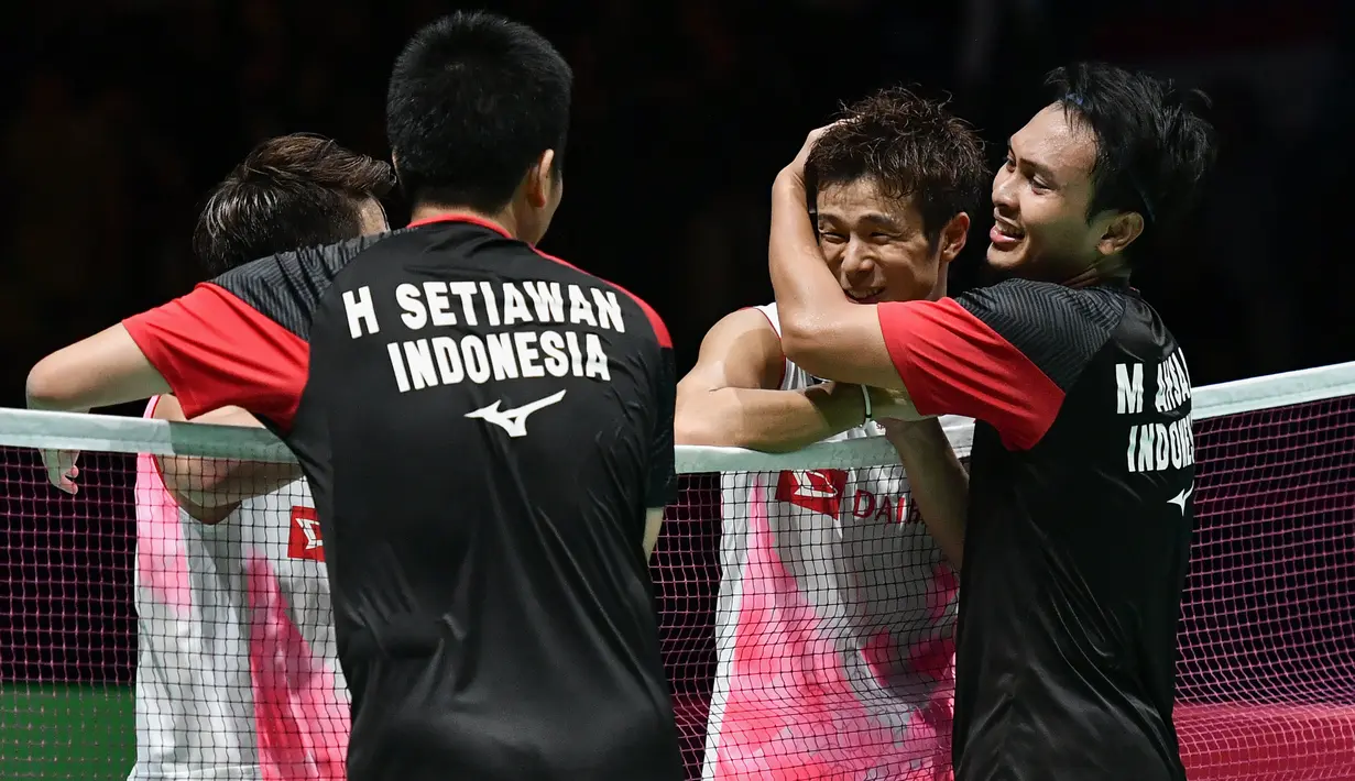 Ganda putra Indonesia Hendra Setiawan dan Mohammad Ahsan berpelukan dengan ganda putra Jepang Takuro Hoki dan Yugo Kobayashi usai memenangi babak final Kejuaraan Dunia Bulu Tangkis 2019 di Swiss, Minggu (25/8/2019). Ahsan/Hendra menang dengan skor 25-23, 9-21, 21-15. (FABRICE COFFRINI/AFP)
