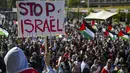 Para pengunjuk rasa memegang poster dan bendera Palestina selama unjuk rasa pro-Palestina, di Lausanne, Swiss, Sabtu, 21 Oktober 2023. (Jean-Christophe Bott/Keystone via AP)