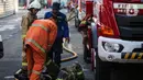 Petugas pemadam kebakaran membantu rekannya setelah melakukan pendingan di Kejaksaan Agung RI yang terbakar, Minggu (23/8/2020). Kebakaran di gedung Kejaksaan Agung pada Sabtu (22/8) malam akhirnya padam dan kini bangunan tersebut menyisakan bagian hitam legam. (Liputan6.com/Faizal Fanani)