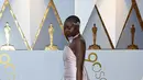 Aktris Danai Gurira berpose di karpet merah ajang Piala Oscar 2018, Los Angeles, Minggu (4/3).  Pemeran Okoye dalam film "Black Panther" ini tampil stunning dengan gaun merah muda sederhana beserta aksesori silver di tubuhnya. (VALERIE MACON / AFP)