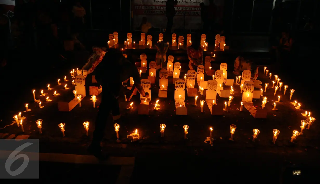 Aktivis menyalakan lilin diantara replika nisan korban pelanggaran HAM masa lalu saat peringatan 19 tahun reformasi di Galeri Cipta 2 TIM, Jakarta, Jumat (12/5). Para aktivis juga menyanyikan lagu perjuangan. (Liputan6.com/Helmi Fithriansyah) 