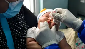 Seorang ibu menggendong bayinya saat petugas kesehatan memberikan vaksin polio di sebuah Pukesmas di Banda Aceh, Aceh, Senin (15/6/2020). Memasuki tatanan normal baru, pelayanan imunisasi anak kembali dibuka setelah sebelumnya sempat terhenti akibat pandemi COVID-19. (CHAIDEER MAHYUDDIN/AFP)