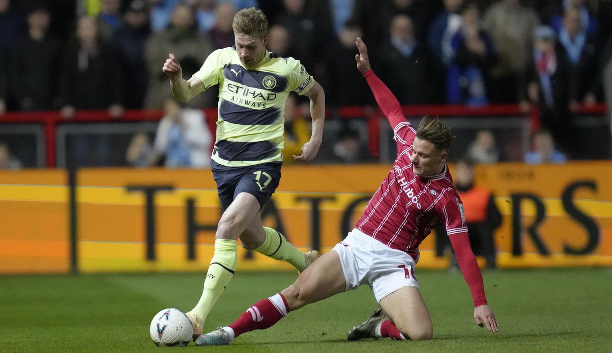 Pemain Manchester City, Kevin De Bruyne (kiri) berusaha melewati pemain Bristol City, Cameron Pring pada laga putaran kelima Piala FA 2022/2023 di di Ashton Gate, Rabu (1/3/2023) WIB. De Bruyne sukses melesatkan satu gol untuk kemenangan 3-0 The Cityzens. (AP Photo/Kirsty Wigglesworth)