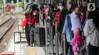 Seorang porter membantu membawa barang bawaan penumpang di Stasiun Pasar Senen, Jakarta, Selasa (26/4/2022). Sepekan menjelang Lebaran, lonjakan jumlah penumpang kereta api sudah mulai terlihat pada Selasa siang ini, dan diperkirakan akan terus bertambah hingga 30 April atau H-2 Idul Fitri. (Liputan6.com/Faizal Fanani)