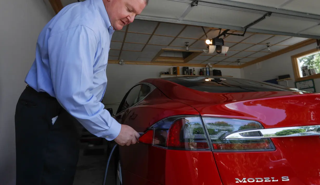 Jeff Solie memasang mobil sedan Tesla listrik di rumahnya, New Berlin, Wis (13/07/2017). Mobil Tesla supercepat yang dikendarai Jeff telah menempuh jarak 72 kilometer. (AP Photo / Morry Gash)