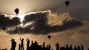 Pengunjung menyaksikan Festival Balon Udara Gilboa di dekat Kibbutz Ein Harod, Lembah Jizreel, Israel (4/8). Acara ini juga dimeriahkan dengan pertunjukan paragliders, paramotor dan karya para seniman udara. (AFP Photo/Manahem Kahana)