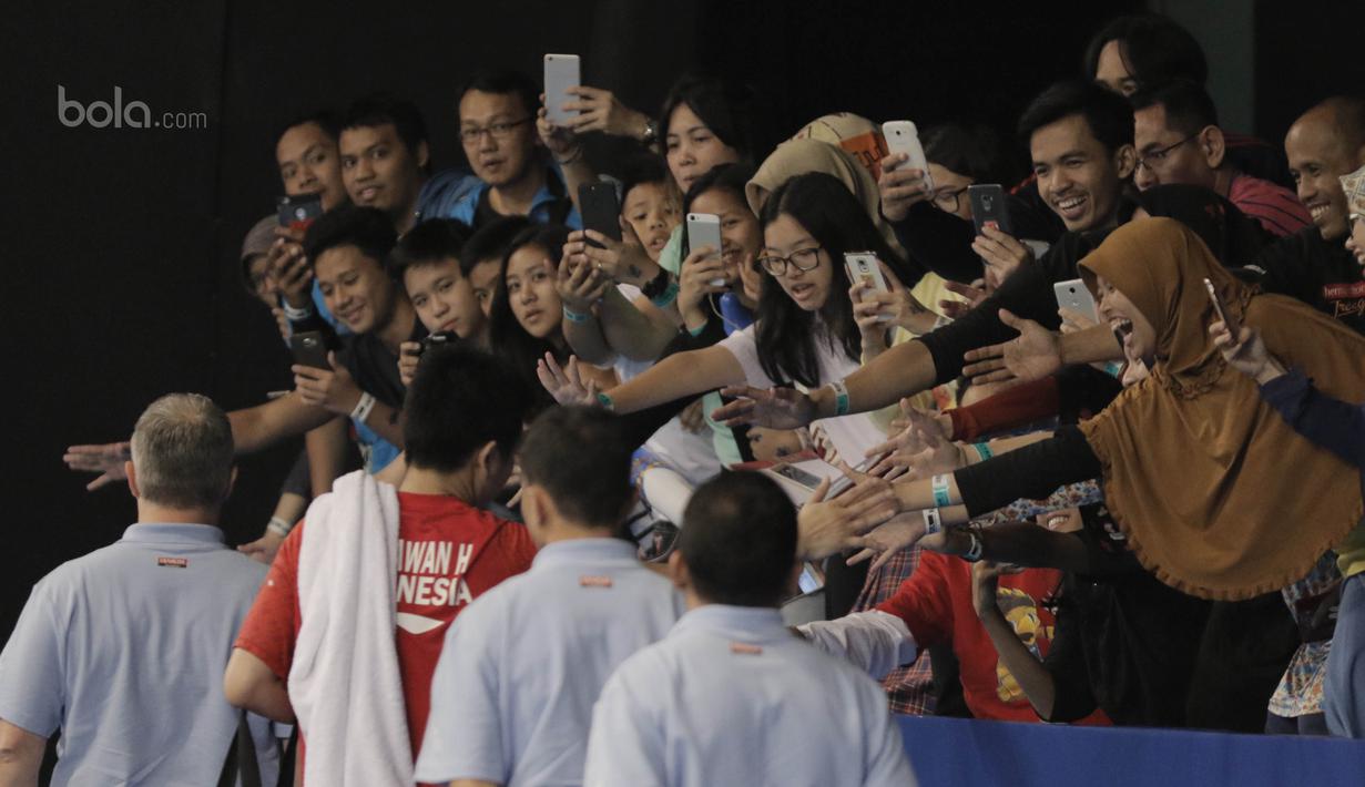  Suporter memfoto dan menyalami pebulutangkis, Hendra Setiawan, saat menyaksikan Indonesia Open 2017. Ajang ini juga menjadi kesempatan pecinta Bulutangkis untuk menyaksikan langsung atlet nasional dan internasional berlaga.(Bola.com/M Iqbal Ichsan)