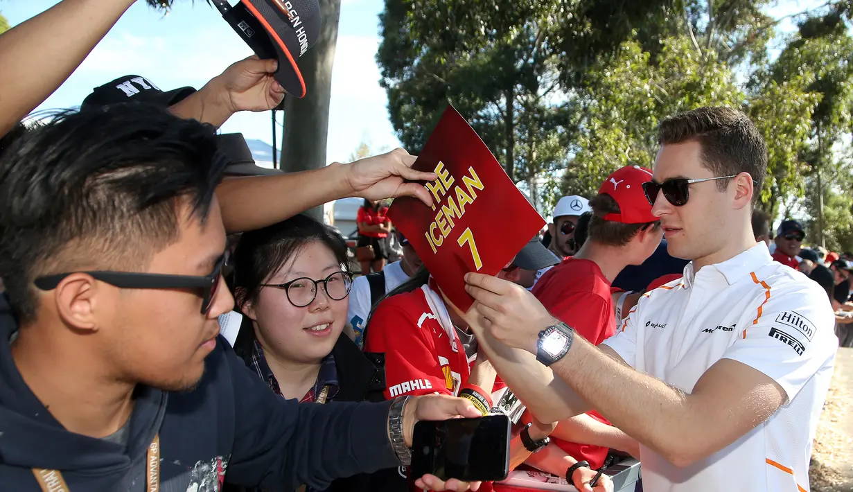 Pembalap tim McLaren, Stoffel Vandoorne memberi tanda tangan kepada fans sesaat sebelum latihan bebas Formula 1 (F1) GP Australia di Melbourne, Jumat (23/3). Balapan F1 GP Australia 2018 sendiri akan bergulir pada Minggu, 25 Maret besok. (AP/Rick Rycroft)
