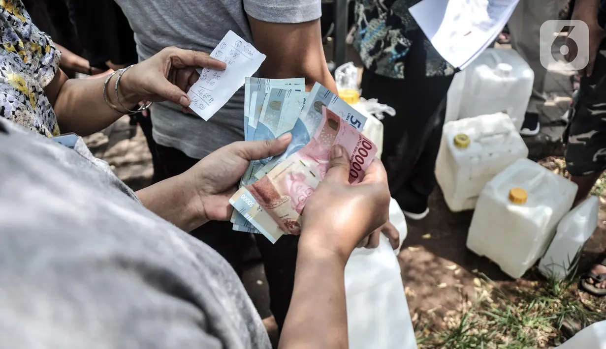 Warga menghitung uang saat akan membeli minyak goreng curah di Pasar Senen, Jakarta, Kamis (17/3/2022). Masih mahal dan langkanya minyak goreng menyebabkan pendistribusian tersebut langsung diserbu warga, baik pedagang maupun pengunjung pasar. (merdeka.com/Iqbal S. Nugroho)