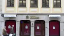 Orang-orang membaca papan nama di jendela sebuah kedai kopi yang tutup di Munich, Jerman, Selasa (23/3/2021). Jerman juga memberlakukan beberapa pembatasan baru, termasuk menutup sebagian besar kehidupan publik selama Paskah, dalam upaya menurunkan infeksi virus corona. (AP Photo/Matthias Schrader)