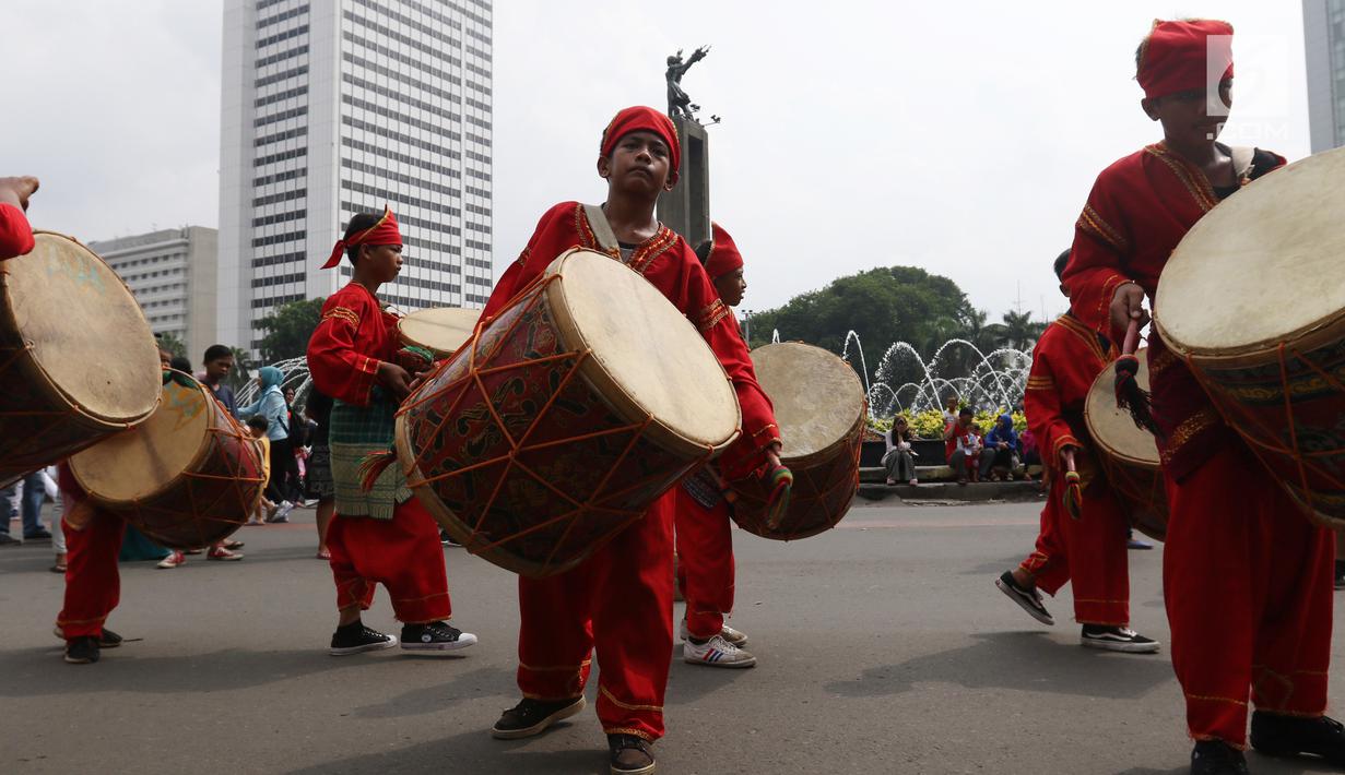 Seniman cilik memainkan alat musik tambur khas Minangkabau saat car free day (CFD) di Jakarta, Minggu (13/1). Pertunjukan ini juga sekaligus untuk mengenalkan keberagaman budaya Nusantara. (Liputan6.com/Angga Yuniar)