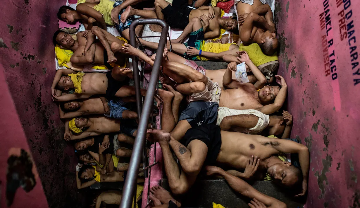 Sejumlah narapidana tidur berdesakan di tangga yang berada di dalam penjara Quezon City di Manila, Filipina, 19 Juli 2016. Setiap sel yang diperuntukkan untuk 20 tahanan, dihuni antara 160-200 tahanan dan harus berbagi ruang secara adil. (Noel Celis/AFP)
